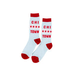 A pair of crew socks in light blue with red cuffs, heels, and toes, featuring the text 'CHI TOWN' and four stars printed in red on the side.