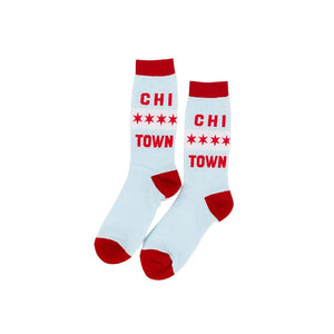 A pair of crew socks in light blue with red cuffs, heels, and toes, featuring the text 'CHI TOWN' and four stars printed in red on the side.