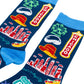 A pair of dark navy crew socks featuring colorful Chicago-themed graphics, including the Chicago skyline, a yellow fedora hat, a green Ferris wheel, and a Route 66 sign, shown on a white background.
