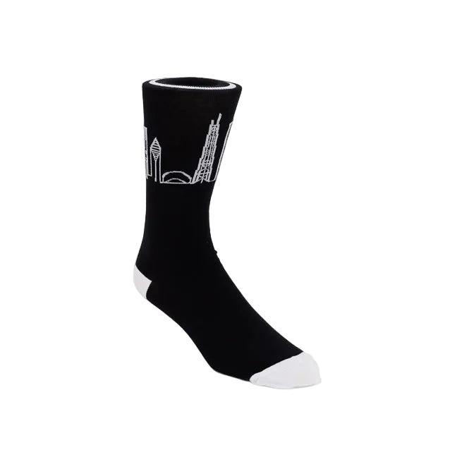 A single black crew sock with a white line-art graphic of the Chicago skyline on the upper cuff, finished with white toe and heel accents, shown against a plain white studio background.