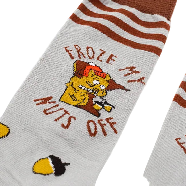 A pair of grey and brown tall socks featuring a shivering squirrel, scattered acorns and text "Froze My Nuts Off" against a white background.