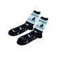 A pair of crew socks on a plain white background. The socks are dark navy with a light blue graphic on the upper calf showing a figure ice fishing with the text 'SURROUNDED BY ICE HOLES', and a lower section with light blue fish and bubbles.