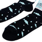 A pair of crew socks on a plain white background. The socks are dark navy with a light blue graphic on the upper calf showing a figure ice fishing with the text 'SURROUNDED BY ICE HOLES', and a lower section with light blue fish and bubbles.