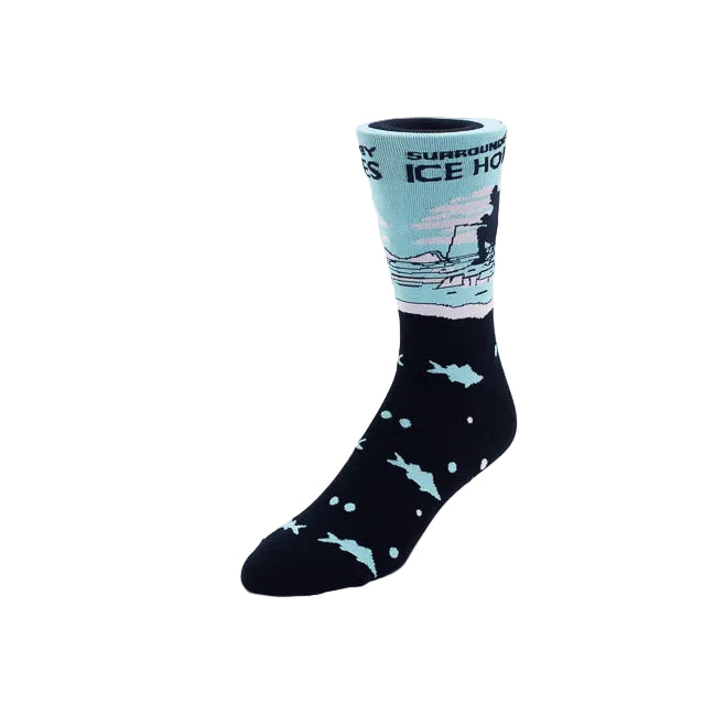 A single crew sock on a white background. The lower half is navy with light blue fish and white dots, while the upper cuff is light blue with a dark silhouette of a fisherman and the text 'SURROUNDED BY ICE HOLES'.