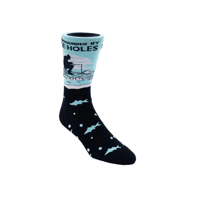 A single crew sock on a white background. The lower half is navy with light blue fish and white dots, while the upper cuff is light blue with a dark silhouette of a fisherman and the text 'SURROUNDED BY ICE HOLES'.