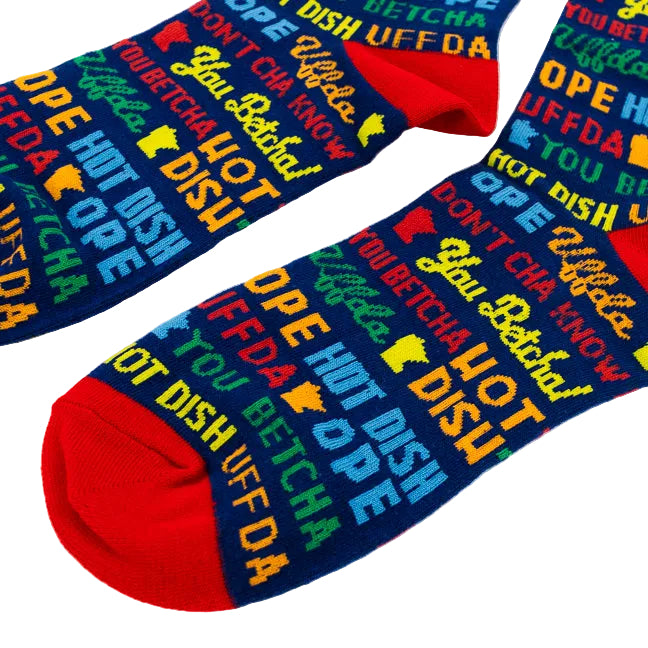 A pair of novelty socks with a dark blue background covered in colorful text and graphics, featuring red toes and heels, displayed on a white background.