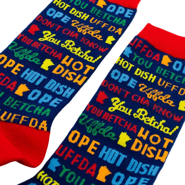 A pair of crew socks with a bold multicolor graphic print featuring classic Minnesota words and phrases in blue, yellow, green, and red, with red cuffs and toes, displayed on a clean white background.