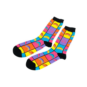 A pair of crew socks with a vibrant multicolor grid pattern featuring rainbow arches and the text 'THE BEAN' in pink, displayed on a clean white background.