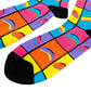 A pair of crew socks with a vibrant, multicolored geometric pattern of pink, orange, yellow, purple, and blue squares, accented with black toes, heels, and soles.