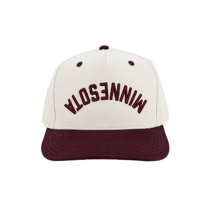 A structured baseball cap with an off-white crown and a dark maroon flat brim. The front of the crown features the word 'MINNESOTA' backwards and upside down embroidered in arched maroon lettering.