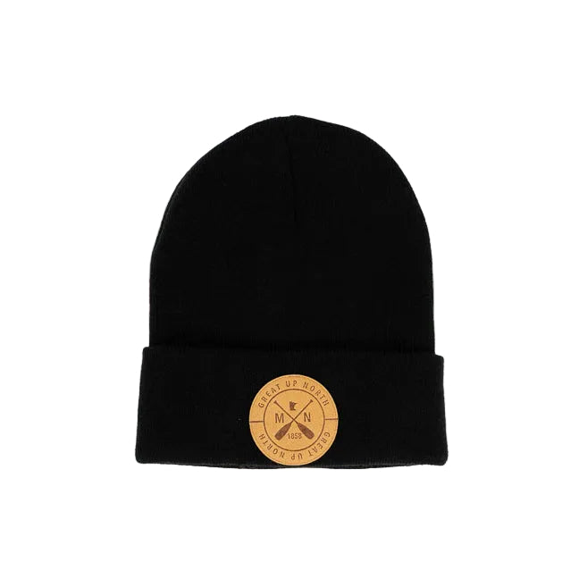 A black knit beanie hat with a folded cuff, featuring a circular tan leather patch on the front with crossed oars and the text 'GREAT UP NORTH' set against a white background.