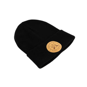 A black knit beanie hat with a folded cuff, featuring a circular tan leather patch on the front with crossed oars and the text 'GREAT UP NORTH' set against a white background.