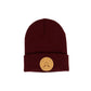 A Zenfandel knit beanie hat with a folded cuff, featuring a circular tan leather patch on the front with crossed oars and the text 'GREAT UP NORTH' set against a white background.