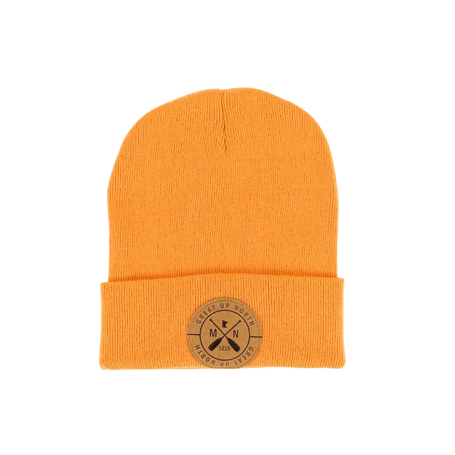 An orange knit beanie hat with a folded cuff, featuring a circular tan leather patch on the front with crossed oars and the text 'GREAT UP NORTH' set against a white background.