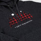 Close-up of a dark heather gray hoodie featuring a red and black buffalo plaid graphic with white text reading 'The Great Northwoods' and a small white bird logo.