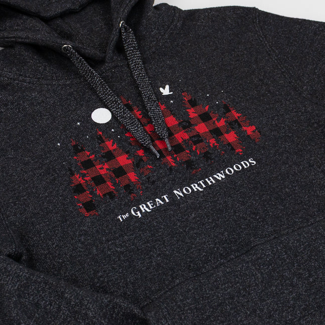 Close-up of a dark heather gray hoodie featuring a red and black buffalo plaid graphic with white text reading 'The Great Northwoods' and a small white bird logo.