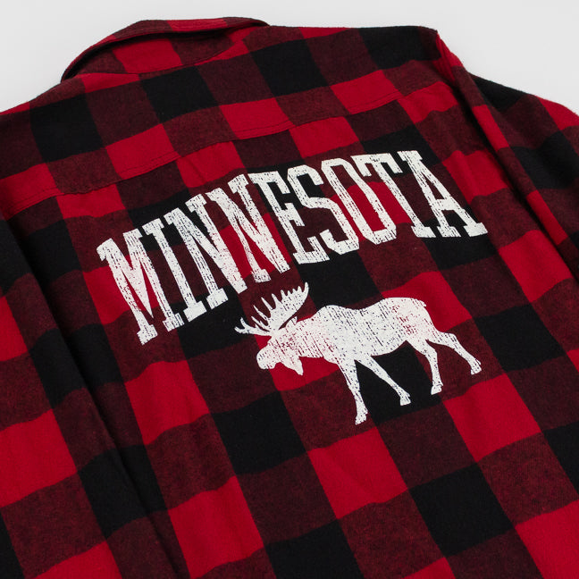 A close-up of a red and black buffalo plaid flannel shirt, showing the back side with a distressed white graphic that reads 'MINNESOTA' above a white moose silhouette.