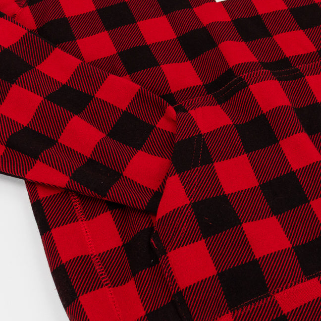 A close-up of red and black buffalo plaid fabric with a visible stitched pocket, laid flat on a white background.