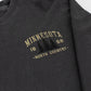 Close-up of a dark charcoal gray long-sleeve t-shirt with a distressed tan graphic on the chest reading 'MINNESOTA 1858 -NORTH COUNTRY-' with pine tree silhouettes.