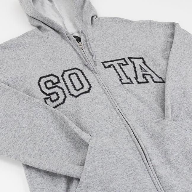 A close-up of a sport gray zip-up hoodie with 'SOTA' embroidered in black varsity-style block letters across the chest, shown on a plain white background.