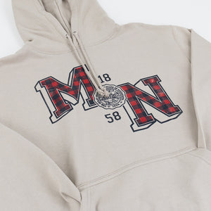 A close-up of a beige pullover hoodie featuring a large collegiate-style 'MN,' the numbers '18' and '58' and a circular seal printed on the chest. The letters 'M' and 'N' are filled with a red and black buffalo plaid pattern.