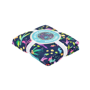 Folded blanket with colorful animal pattern and a label on a white background