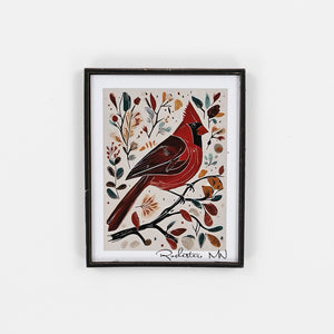 Framed artwork of a red bird on a branch with leaves and flowers on a white background