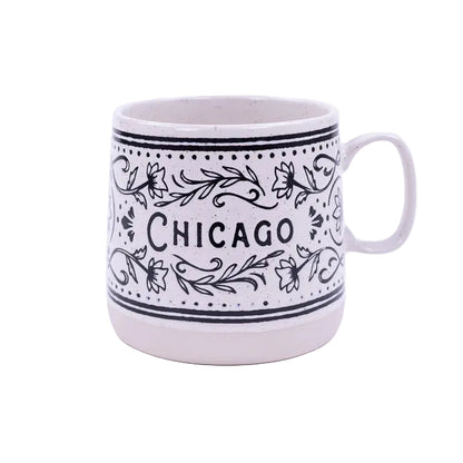 White mug with black floral patterns and 'Chicago' text on a white background
