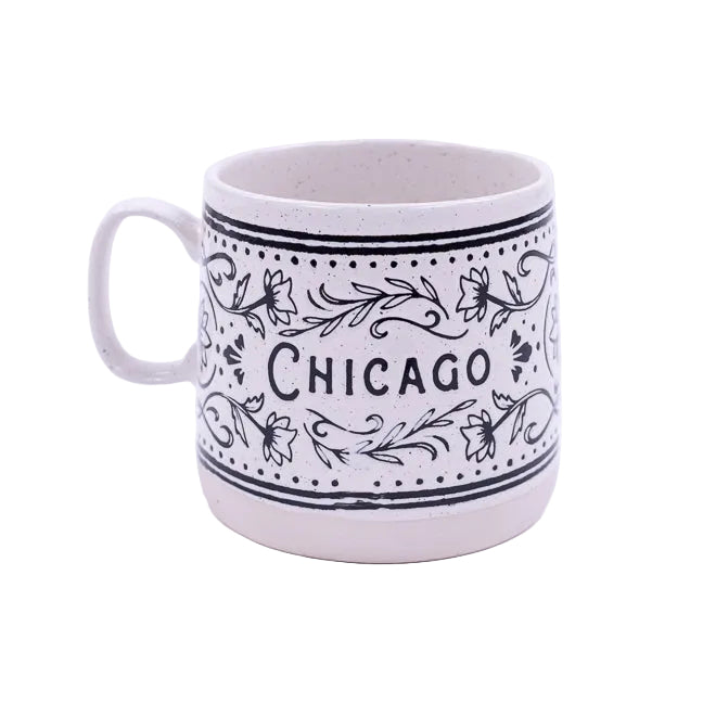 White mug with black floral patterns and 'Chicago' text on a white background