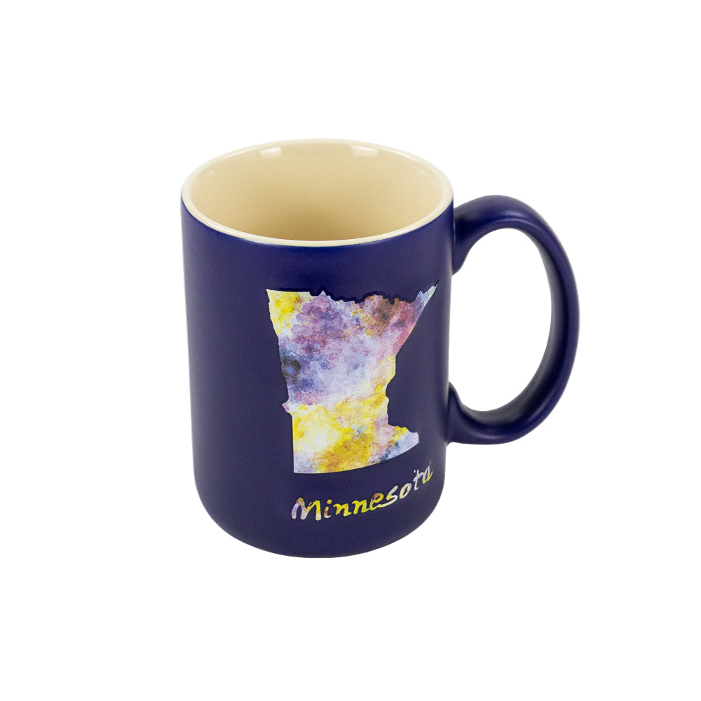 A blue mug with the Minnesota state shape in watercolor design and the word Minnesota in water color print underneath set against a white background.