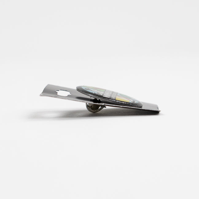 Side view of a metal pin on a black card against a white background.