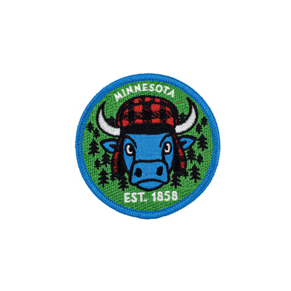 Minnesota-themed patch with a blue bull, red plaid hat, and green background on a white background