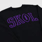 A black crewneck sweatshirt featuring the word 'SKOL' in purple varsity-style block letters across the chest, with the letter 'O' designed as a football.