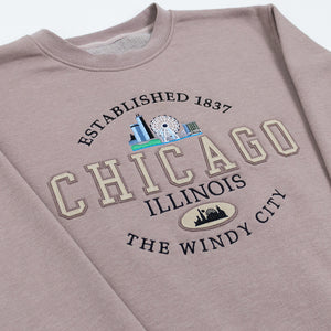 Rose gold colored sweatshirt with 'Chicago, Illinois' text and skyline graphics on a white background