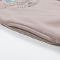 Close up of a pocket in a rose gold sweatshirt with a Chicago design.