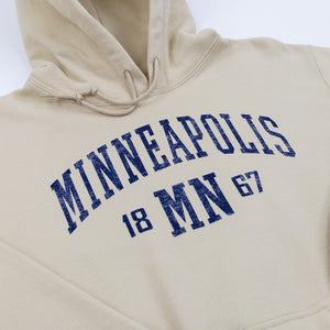 Sand-colored hoodie with 'Minneapolis MN 1867' text in blue across the front on a white background