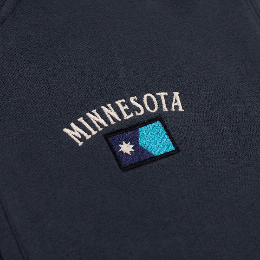 Navy sweatshirt with 'MINNESOTA' text and a flag patch on a dark background