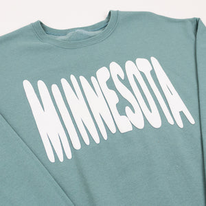 Teal sweatshirt with 'MINNESOTA' printed in white bouncy letters across the front on a white background
