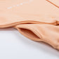 Close-up of a pocket in a peach-colored sweatshirt on a white background