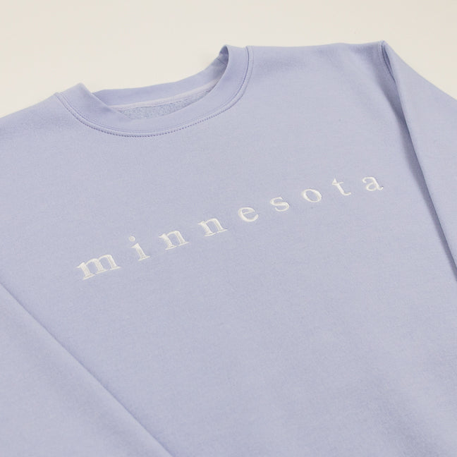 Soft purple sweatshirt with 'minnesota' text on a white background.