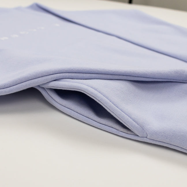 Close-up of a pocket in a soft purple sweatshirt.