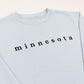 Light blue sweatshirt with 'minnesota' printed on it against a white background