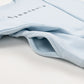 Close-up of a pocket on a light blue sweatshirt with MINNESOTA in small font text across the front.