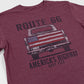 Maroon t-shirt with graphic of a truck and American flag, text 'ROUTE 66 AMERICA'S HIGHWAY NAVY PIER' on a white background.