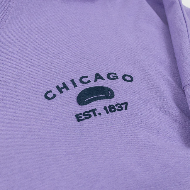 Design of CHICAGO EST 1837 and the Bean in navy against a purple shirt.