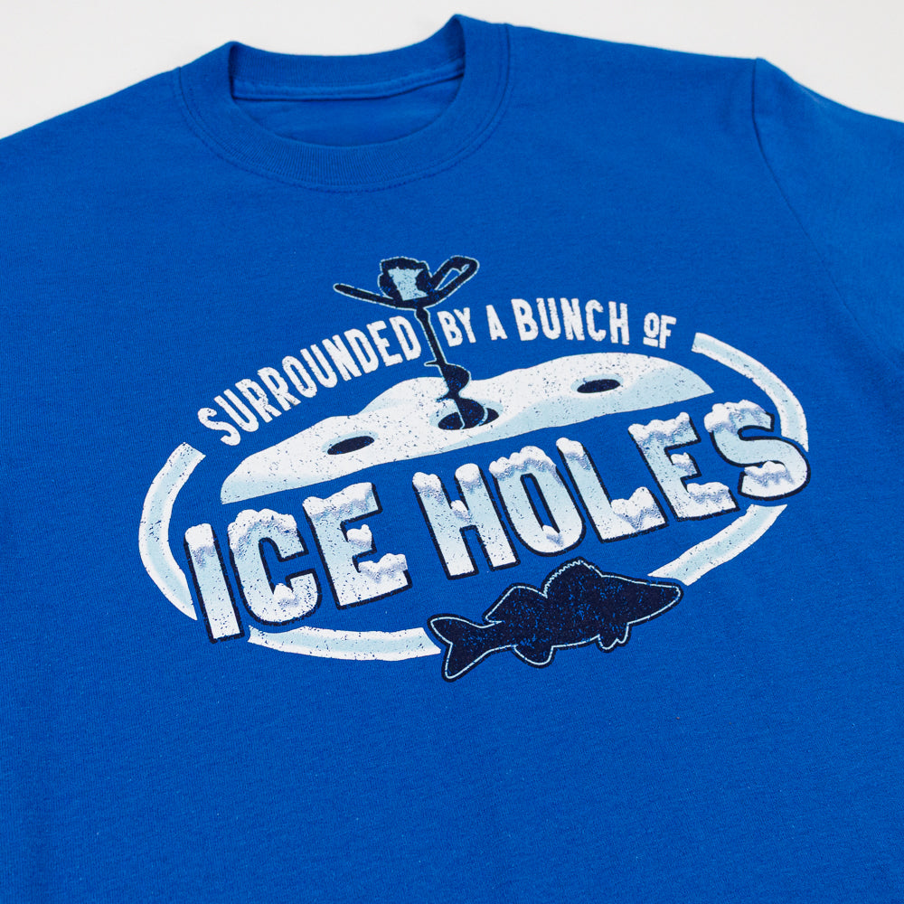 Blue t-shirt with a wintry ice fishing scene and text that reads "Surrounded by a bunch of ice holes."