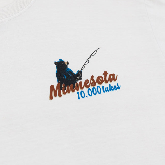 Design featuring a bear fishing and Minnesota 10,000 Lakes text on a Cappuccino colored t-shirt 