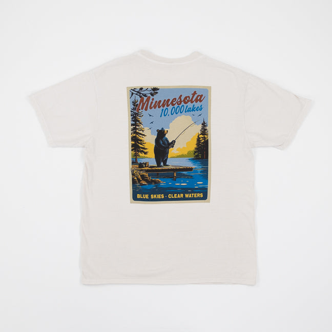 Cappuccino colored t-shirt with a graphic of a bear fishing and 'Minnesota 10,000 Lakes' text on a white background