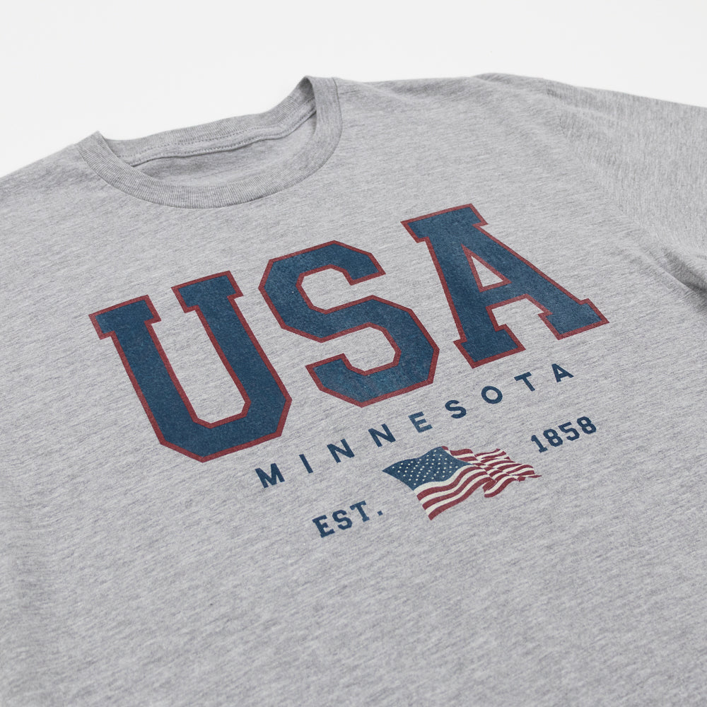 Grey tee shirt that reads USA Minnesota Est. 1858 and a USA flag on a white background.