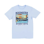 A light blue colored t-shirt with a city scene and text "Rochester, Minnesota Med City" on a white background.